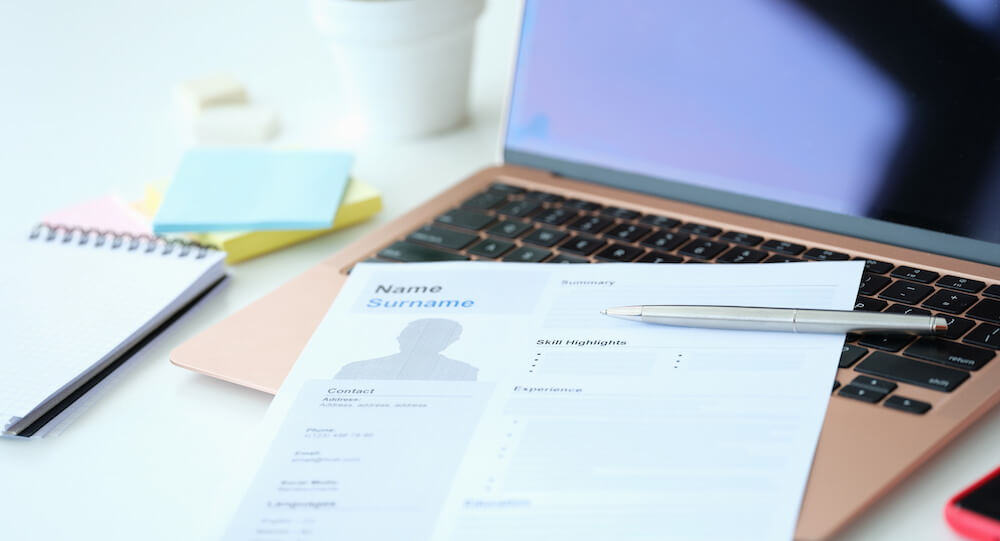 femme qui rédiger son CV papier