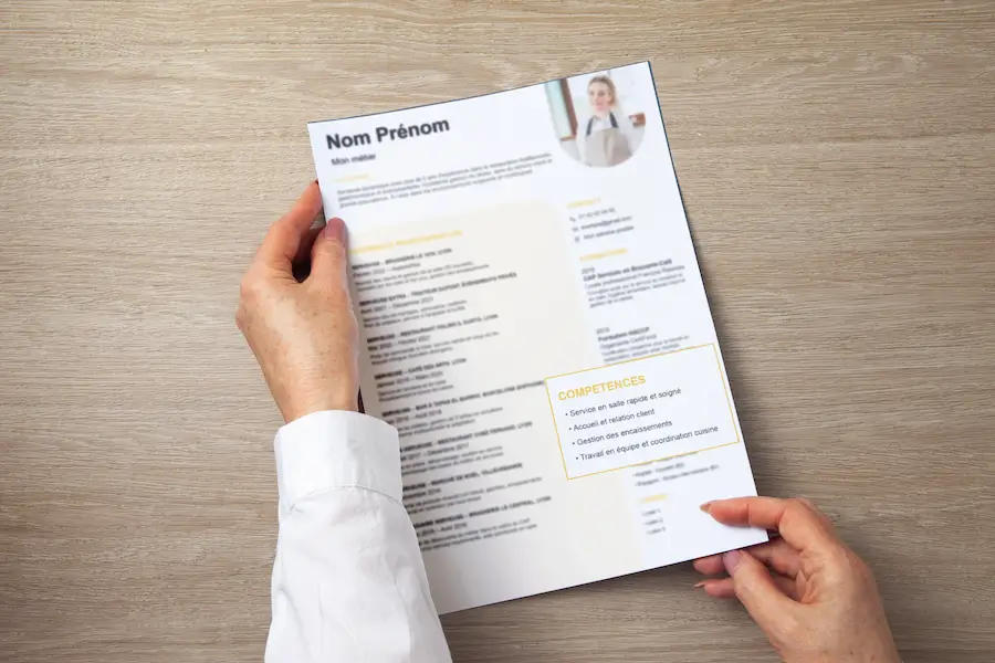 femme portant un CV avec une liste de compétence